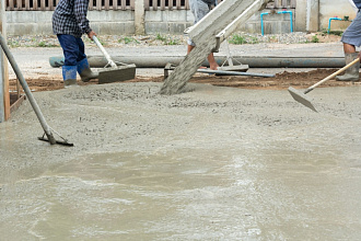 бригада заливает бетонную площадку